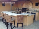 Kitchen with Smooth Stucco Walls and Granite Counters and Backsplash. Tile Wall Detail. Exposed Aggregate Patio